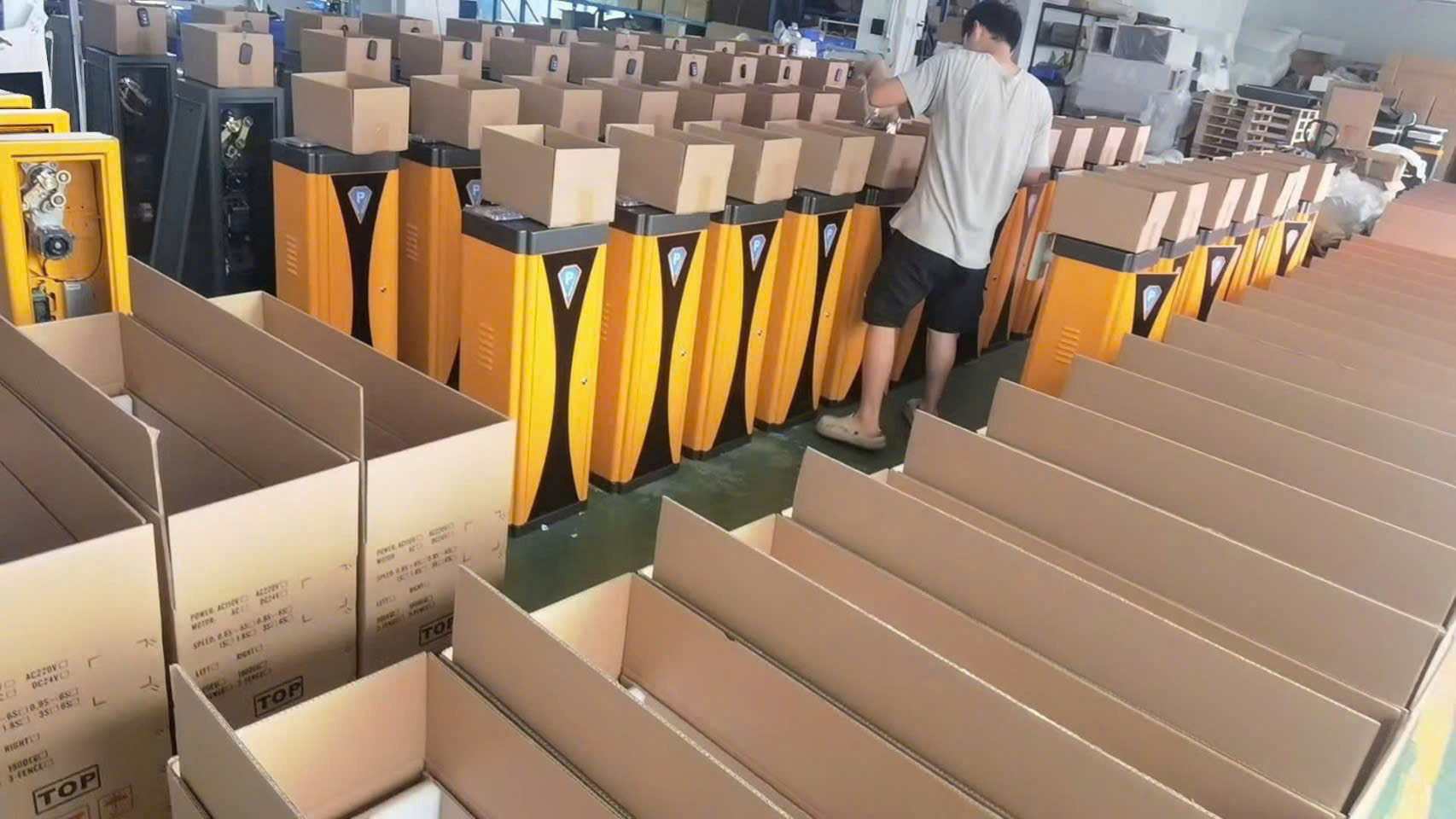 Dây chuyền đóng gói hàng loạt trụ barrier tự động màu vàng trong nhà xưởng sản xuất